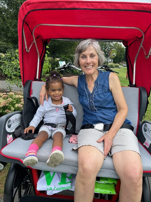 An older woman with a young child on the rickshaw. Rickshaw rides can be intergenerational connections.