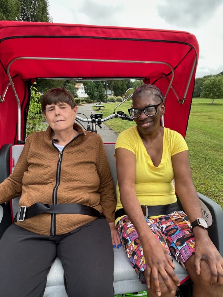 Two women sitting in a bicycle cart