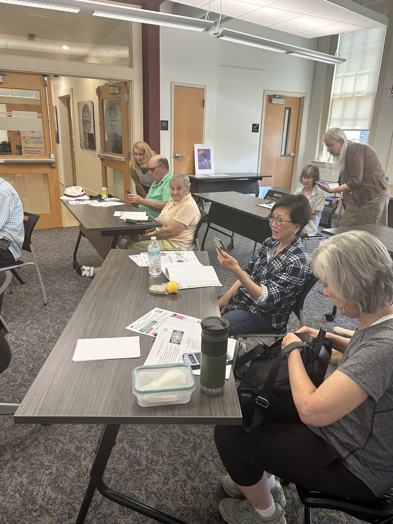 Tech Class with trainer helping students on their smartphones